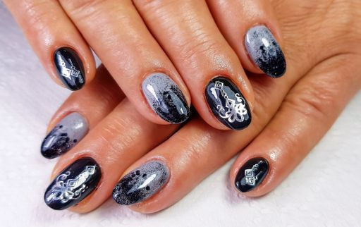 A top view shot of a woman with her modern gel art manicure on a soft fabric surface