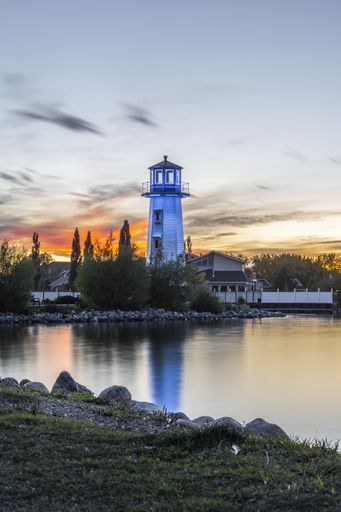 A vertical shot of a blue lighthouse near the shore of Sylvan Lake in Alberta, Canada