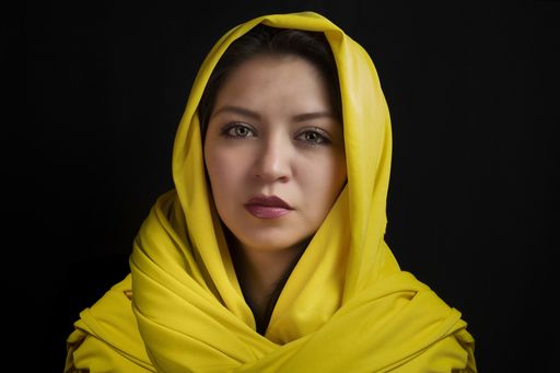 A closeup portrait of a beautiful Caucasian woman with a scarf on her head  isolated on a black background