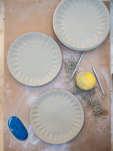 3 Ceramic plates in bisque moulds with pottery tools and sponge