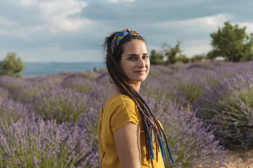 A beautiful young female with dreadlocks in a lavender field with the sea in the background