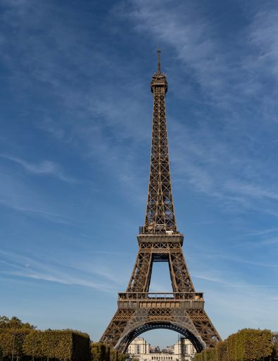A vertical shot of the iconic Eiffel Tower under a bright blue sky