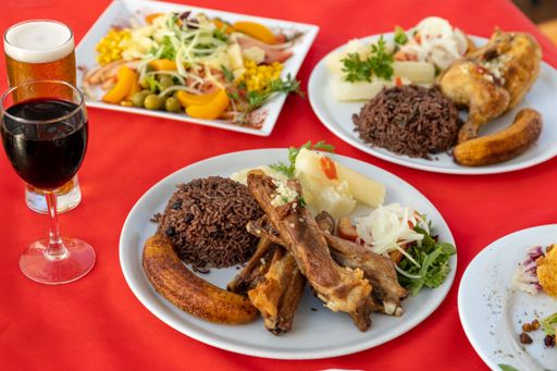 A delicious dinner table with plated of Gallo pinto, meat, salad and wine