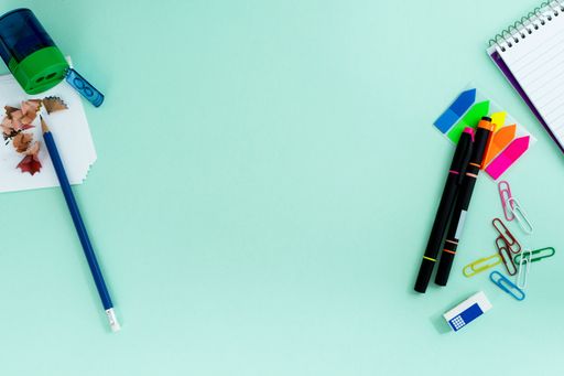 The flat lay of the creative office supplies on the light blue background