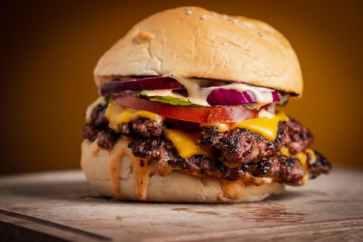 A closeup shot of a juicy hamburger with beef and cheese