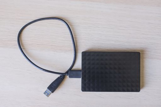 A top view shot of external hard drive for backup on wooden table