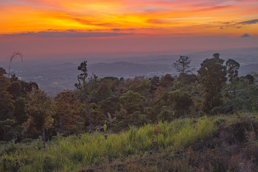The hills covered in greenery under a cloudy sky during a beautiful sunset - great for wallpapers