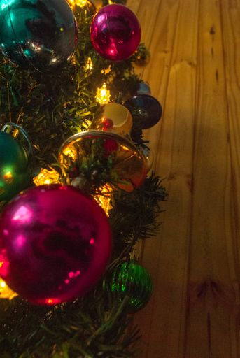A vertical shot of a Christmas tree with shiny decorations