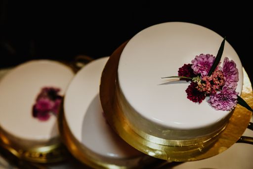 A top view of a wedding cake decorated with purple flowers