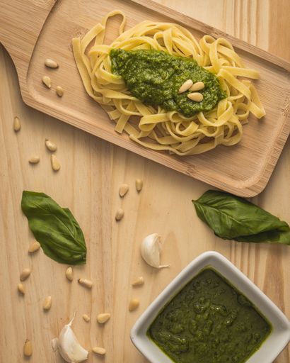A top view of a delicious Pasta Tagliatelle with pesto sauce on a wooden table