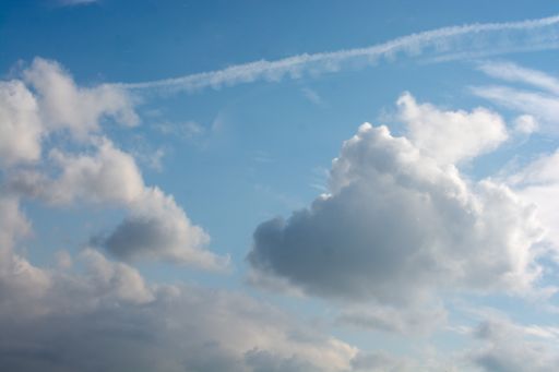 A beautiful shot of fluffy white clouds in a bright blue sky-perfect for wallpapers
