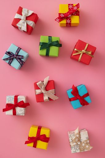 The flat lay of multi-colored gift boxes in the pink background, Christmas mood