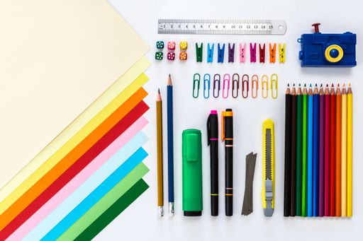 A top view of creative office work tools, paper, pencils on white background