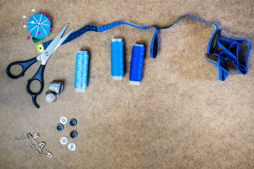 A top view of scissors and sewing supplies on wooden background