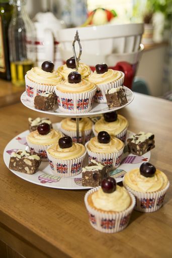 A vertical shot of delicious cupcake with cherry garnish on a wooden table