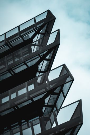 A vertical low angle shot of a modern office building against the blue sky