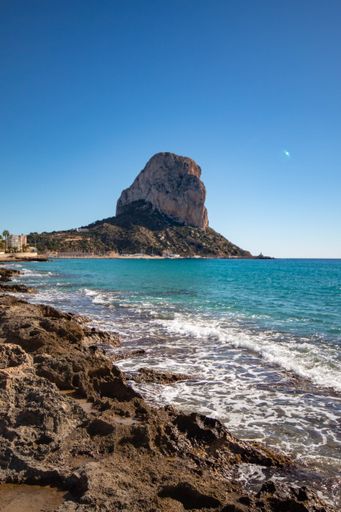 Photo of rock of Ifach of the village of Calpe on the Spanish Costa Blanca with the warm Mediterranean climate and the calm sea.