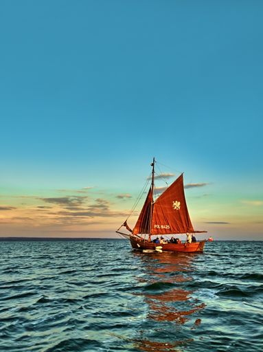 Vistula Lagoon, Poland - July 17, 2020. Yacht with tourists sailing  in Vistula Lagoon at sunset in summer.