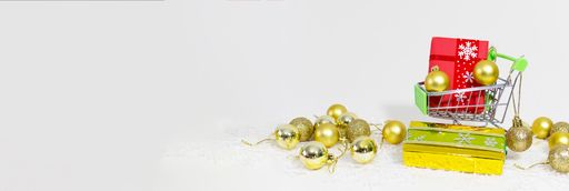 A shopping trolley with gift boxes and golden spheres on snowflakes on a white background