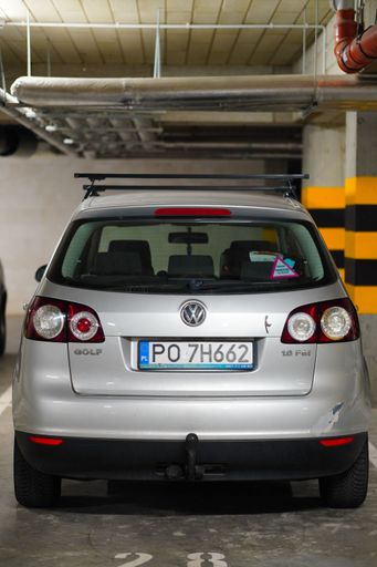 A back of a parked silver colored Volkswagen Golf Plus in a parking