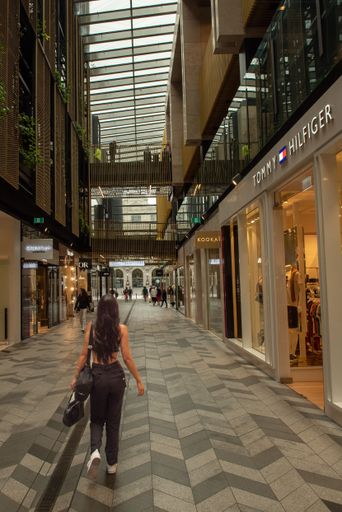 A vertical shot of a young female walking down a shopping street in Auckland, New Zealand