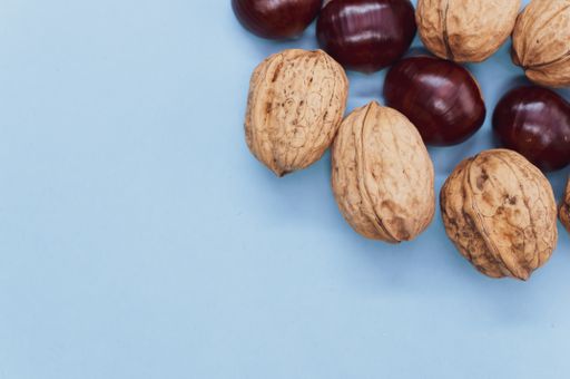 A high angle shot of a background with hazelnuts and walnuts with a copy space