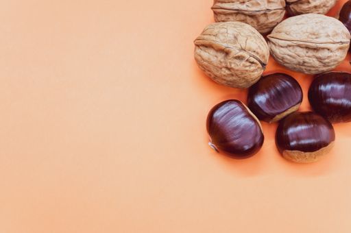 A high angle shot of a background with hazelnuts and walnuts with a copy space
