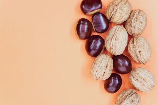 A high angle shot of a background with hazelnuts and walnuts with a copy space