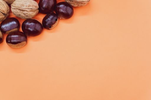 A high angle shot of a background with hazelnuts and walnuts with a copy space