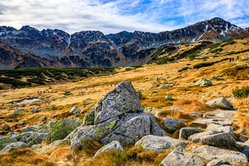 A scenic landscape of Tatra mountains captured in Poland with a group of hikers walking uphill