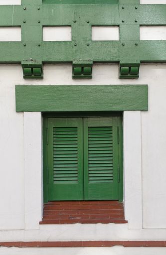 A vertical shot of a window with green shutters