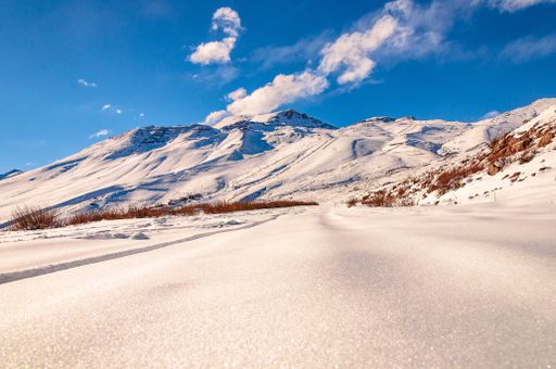 A beautiful low angle shot of a breathtaking mountainous scenery covered in snow in Andes Cordillera, Chile