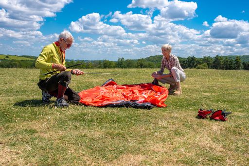 A senior couple preparing for rest, laying out a tent