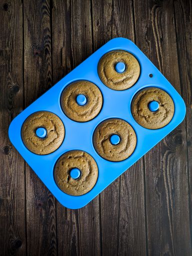 A closeup shot of zenithal plan homemade donuts in blue oven mold. Pastry shop