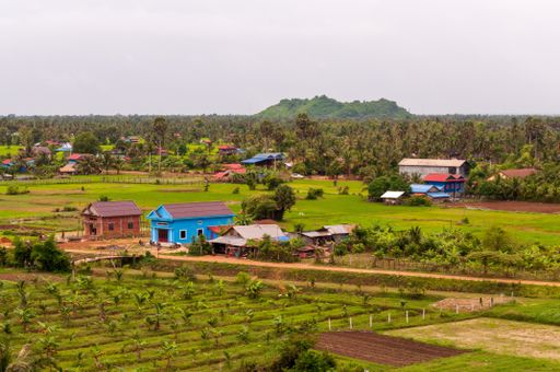 A village surrounded by green scenery under the clear sky in Cambodia in Asia