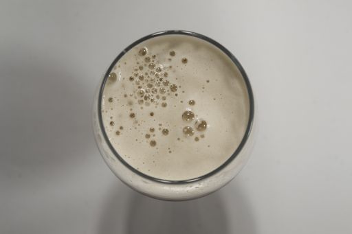 A high angle shot of a beer foam in the glass