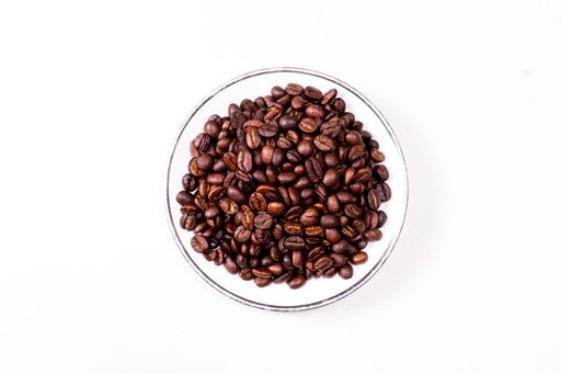 Top View Of A Saucer Full Of Coffee Beans Isolated On White Surface