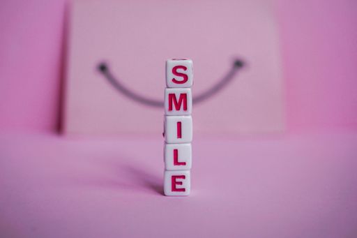 The word smile on a pink surface - a motivational word created with cube letters