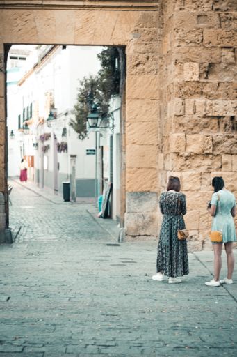A vertical shot of two girls at the entrance of the Jewish quarter in Cordoba, Andalusia, Spain