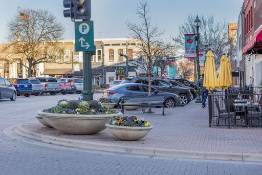 A view of the cars parked by a paved street captured in McKinney, Texas, United States