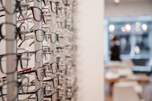 A selective focus shot of a row of glasses on display at an optics store