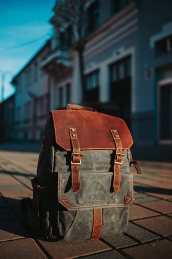A vertical selective focus closeup of a backpack on the ground