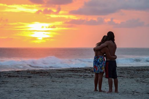 The lovers on the beach during the amazing sunset