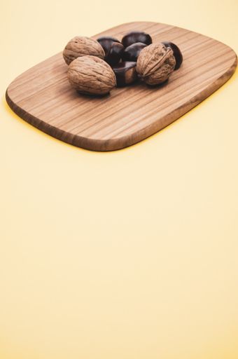 A shot of chestnuts and walnuts on a wooden board
