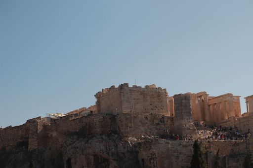 A sunny day in Athens, Greece, with tourists, gathered around the Acropolis
