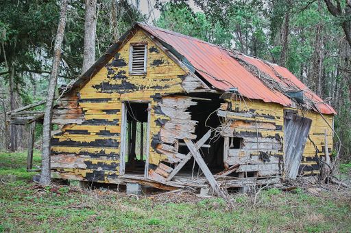 A wooden cabin without a door falling apart from old age in a forest