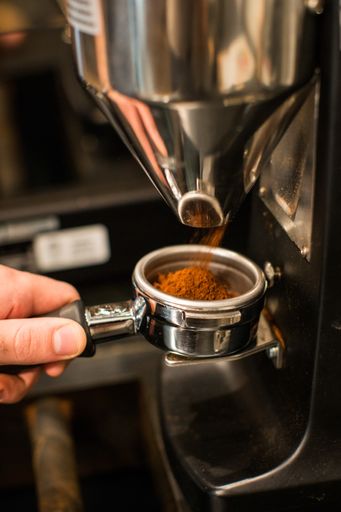 A person making coffee with a coffee making machine