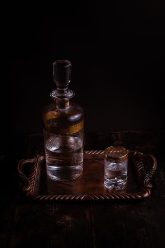 A vertical shot of a vintage tray with a decanter and a glass