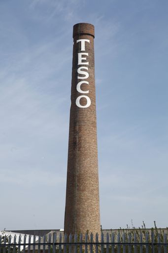 A vertical shot of a painted Tesco sign on a giant chimney in Newcastle, UK