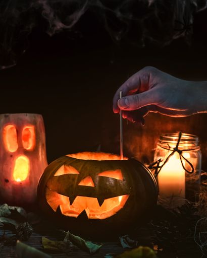 A vertical shot of decorated Halloween pumpkin head jacks with candles